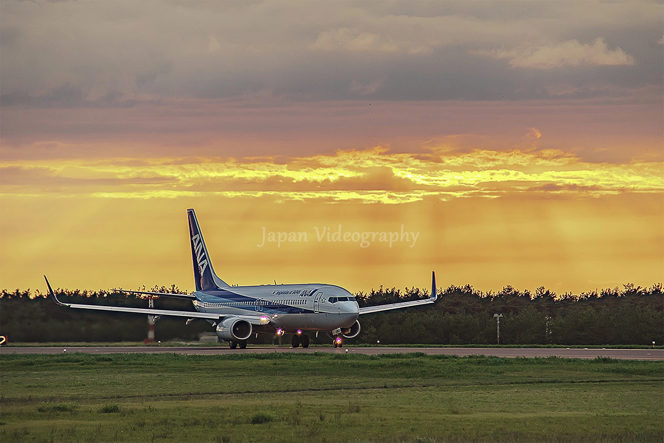 山形県 庄内空港 夕日と飛行機の離陸